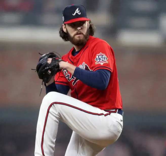 A baseball player is getting ready to throw the ball.